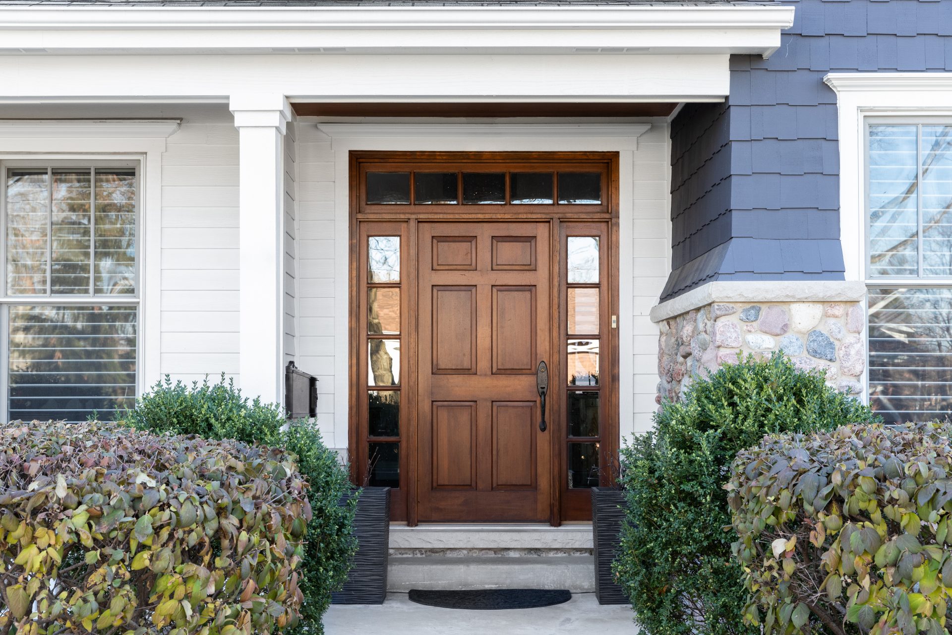 Brown wooden entry door with sidelights on home