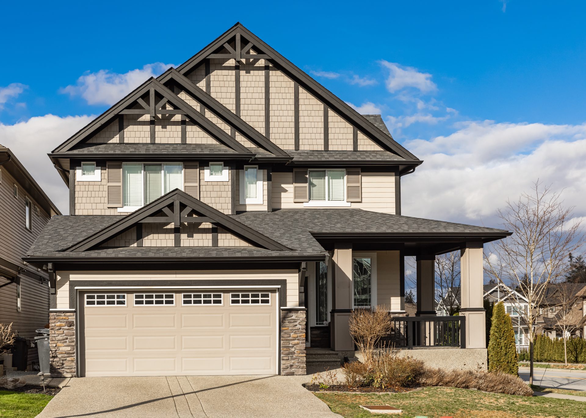 Tan Siding And Stone House With Beautiful Windows Installed
