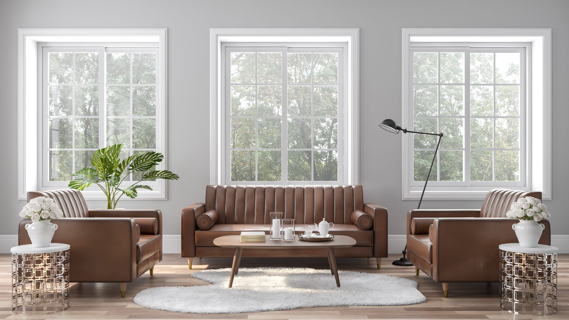 A living room with a brown couch/chair set and three large windows