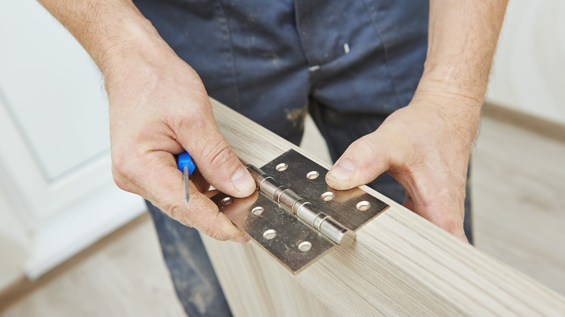 Close view of a door hinge installation in progress