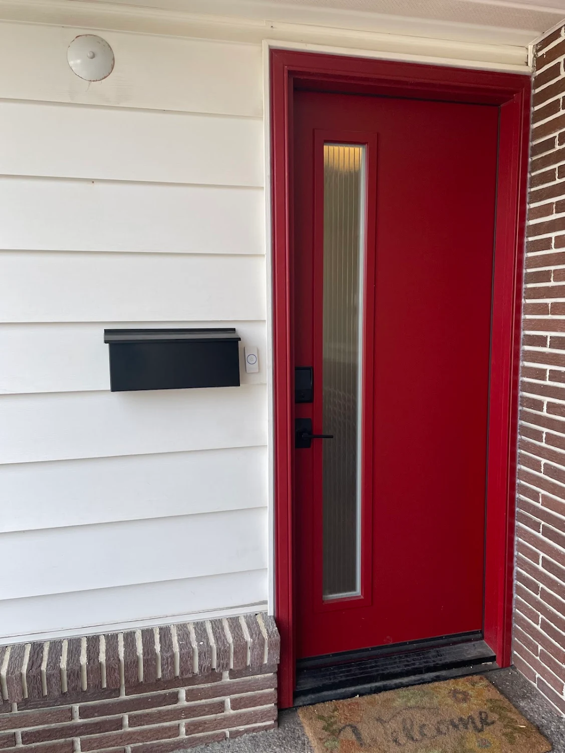 A red front entry door is precisely installed by GreenFox Windows & Doors in Alberta, CA.