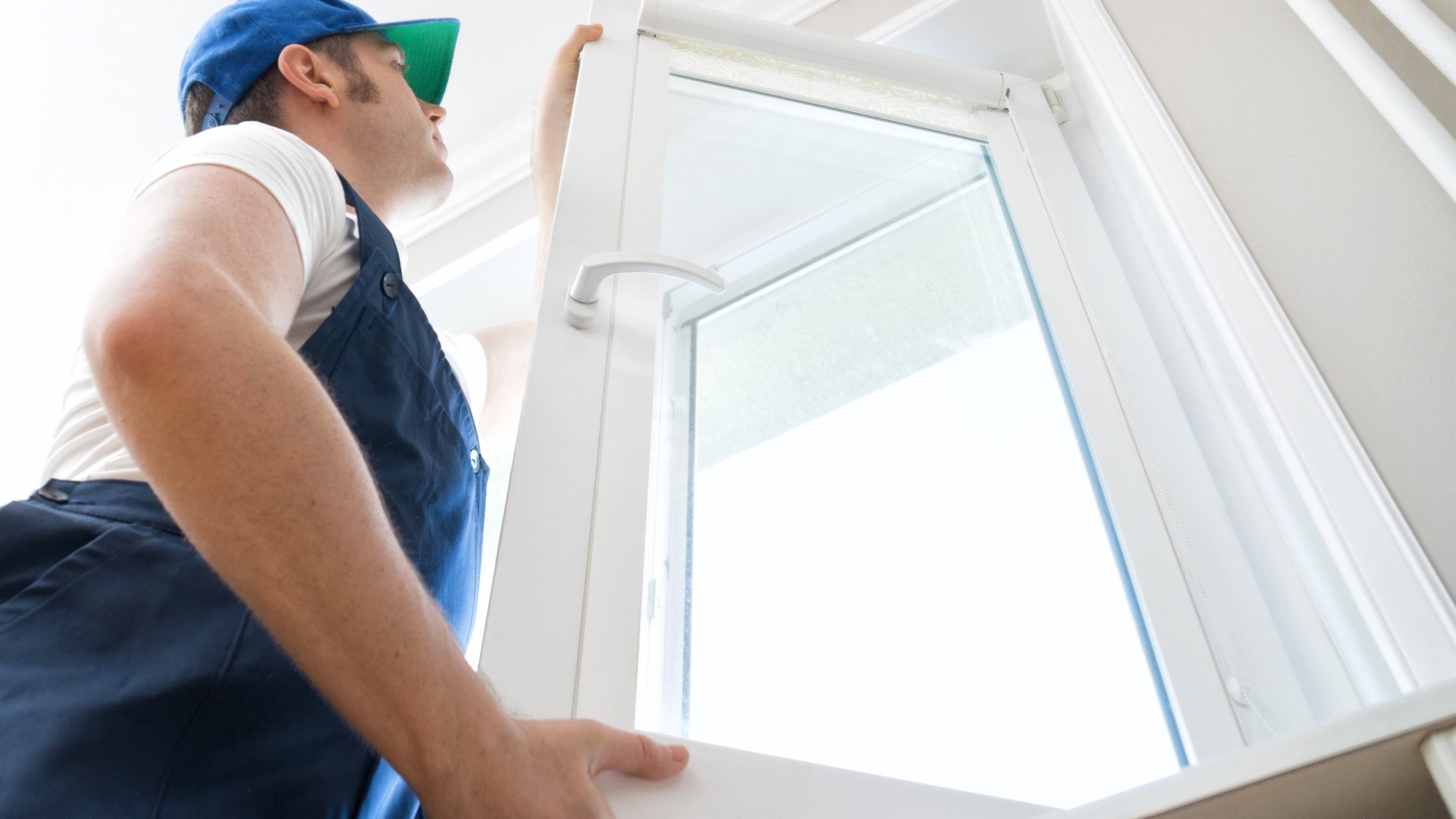 A close, upward-angled view of an installer replacing a window