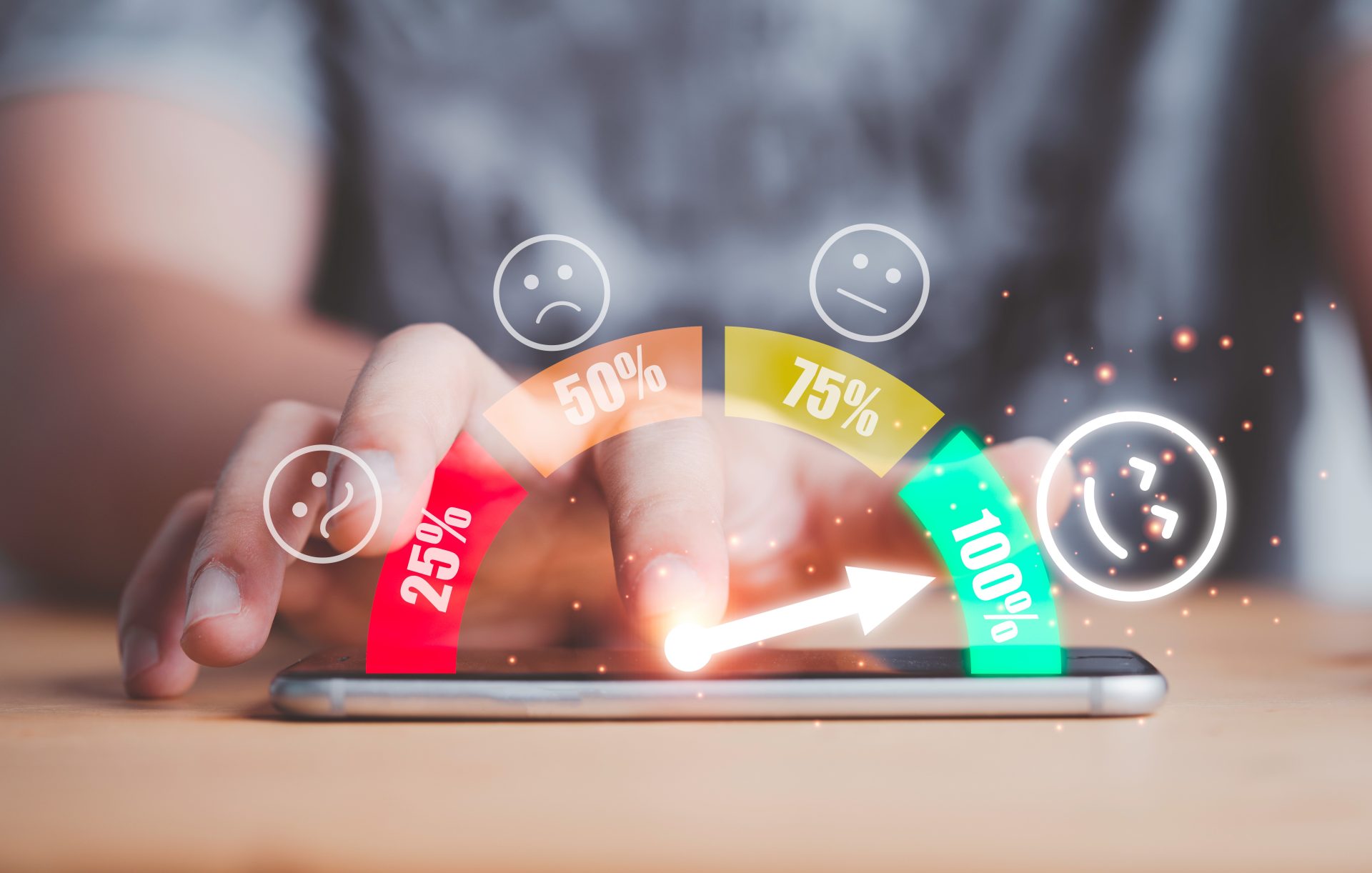 A man using a smartphone lying on a desk. He is touching it with his finger. There are graphics on the image of face icons and percentages representing customer satisfaction.