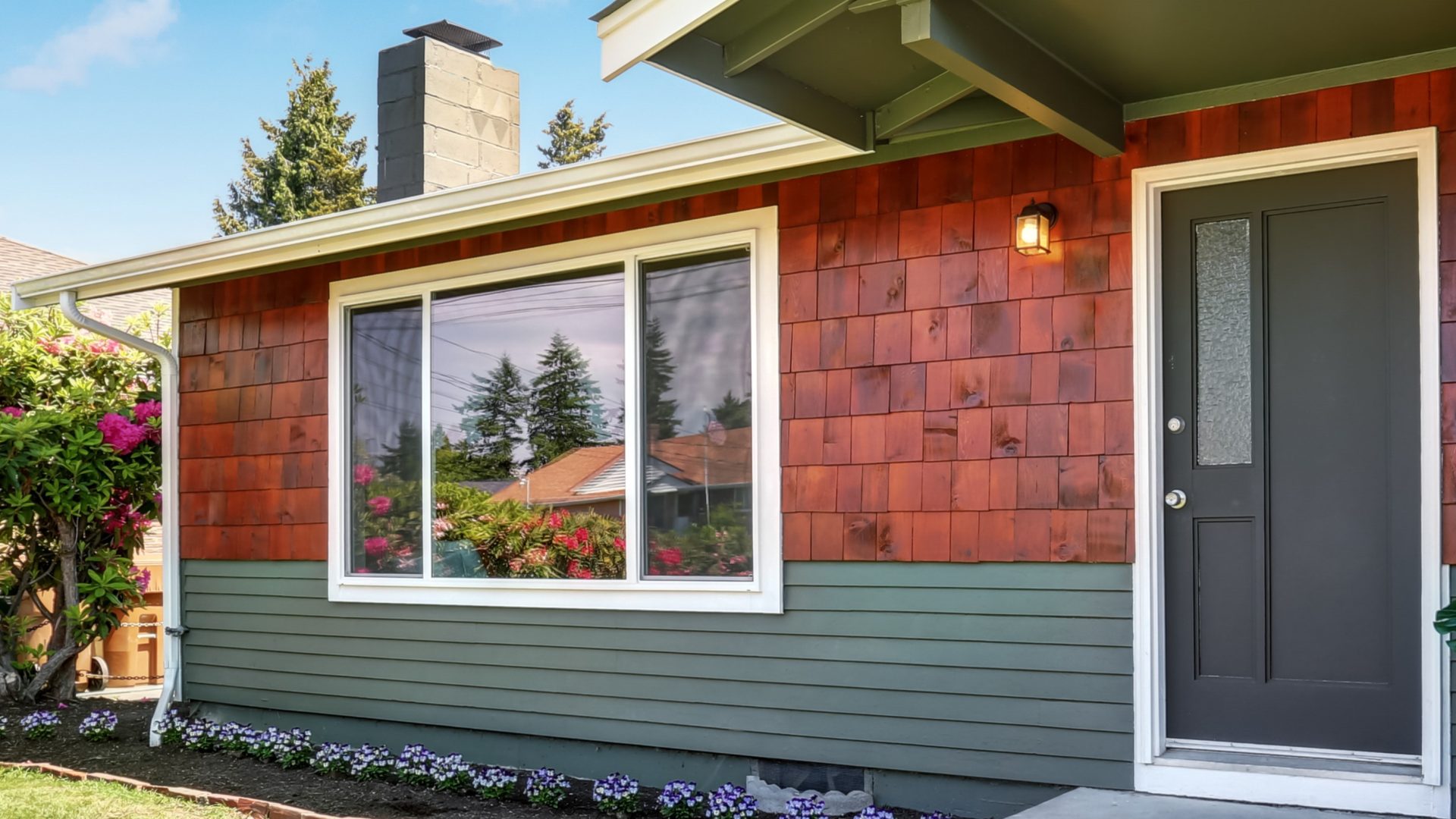 Front exterior view of home with large front window and black entry door