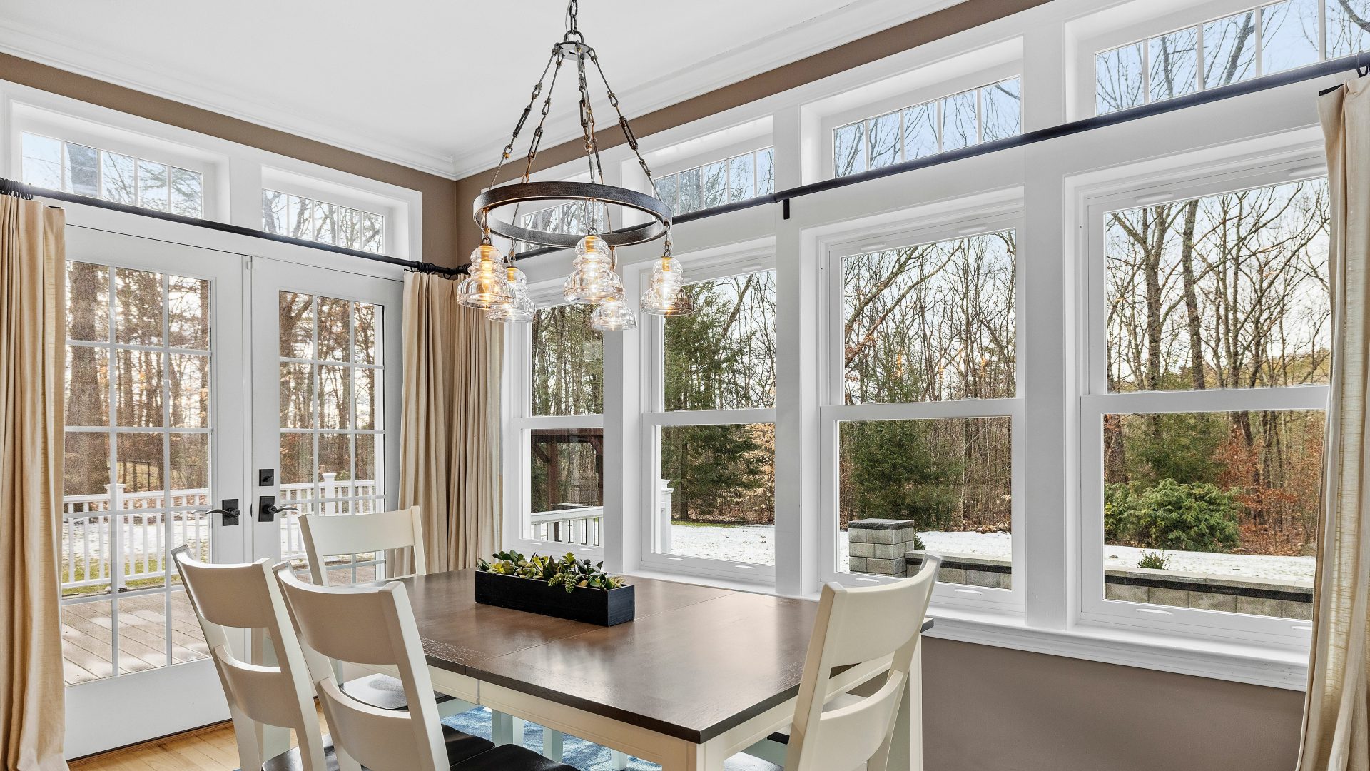 Interior view of home sunroom with lots of windows and beautiful glass doors