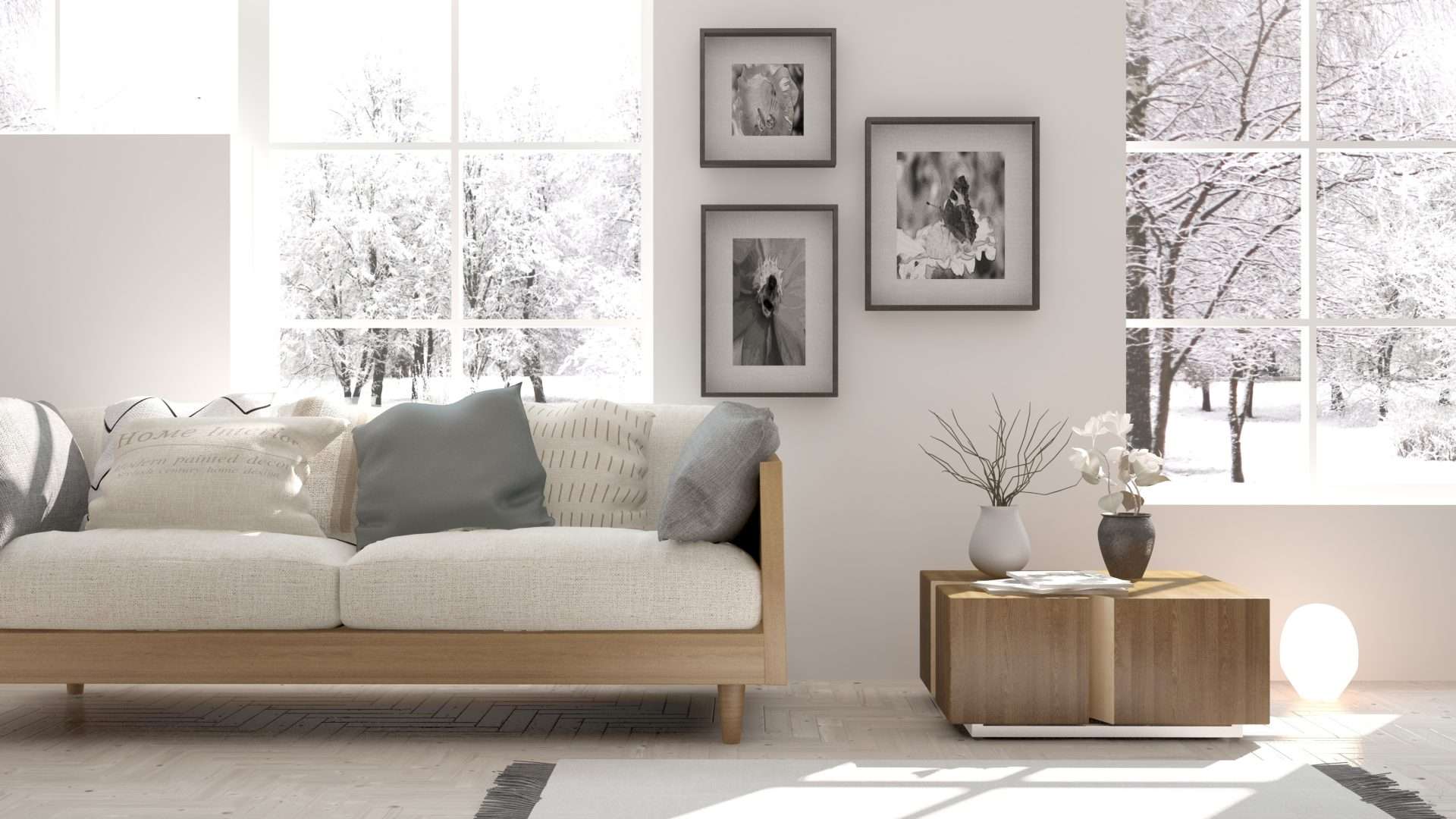Interior view of a cozy modern living room with two large multi-pane windows overlooking a snowy outdoor scene