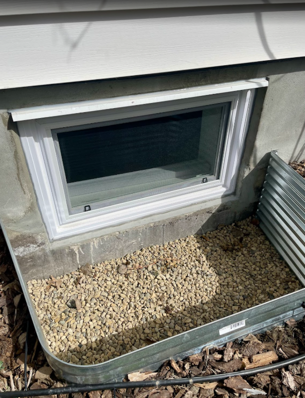 A downward exterior view of Dana L.’s new basement egress window