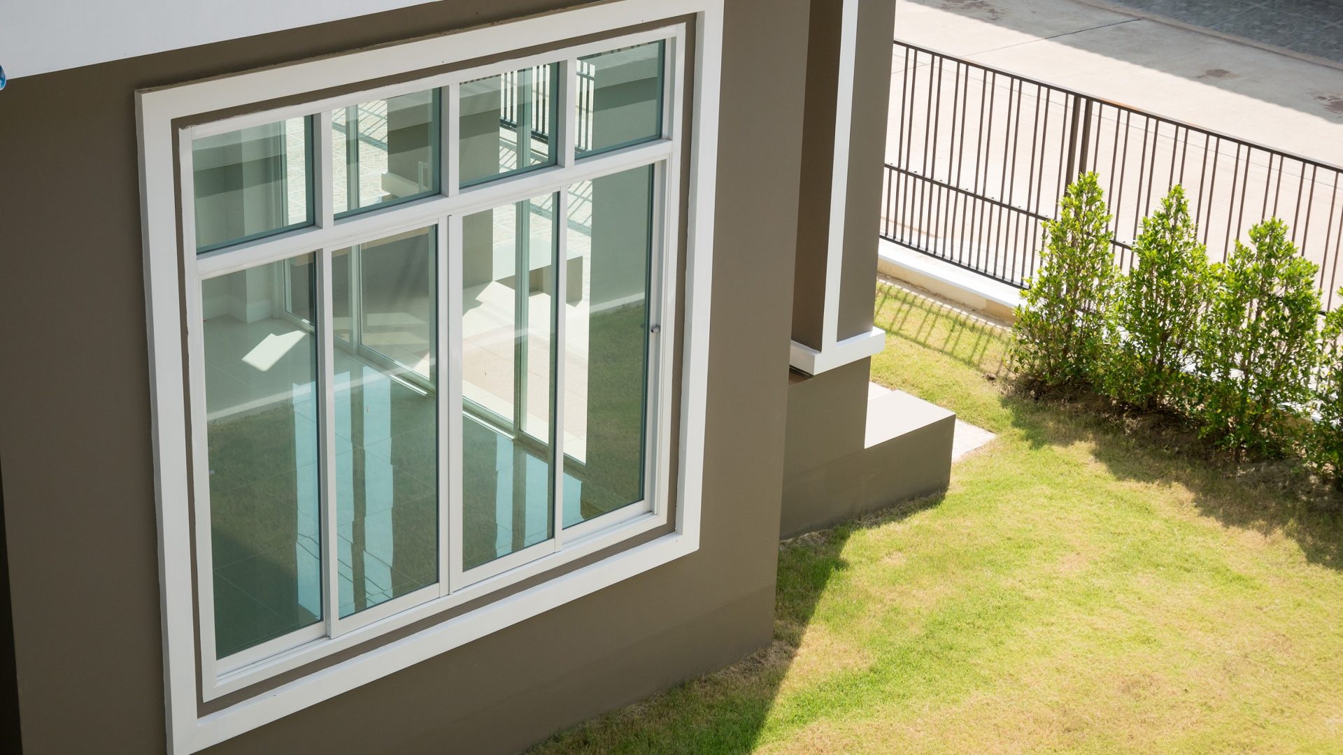 Large window with white frame on a home with brown siding