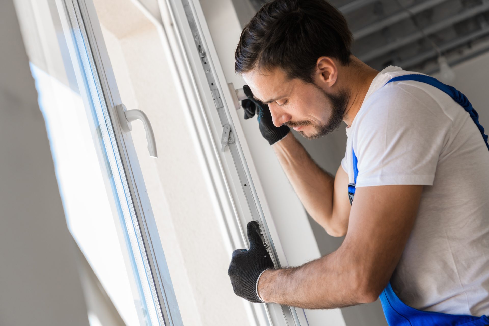 Worker in overalls installing a replacement window in Edmonton, Alberta by GreenFow Windows & Doors