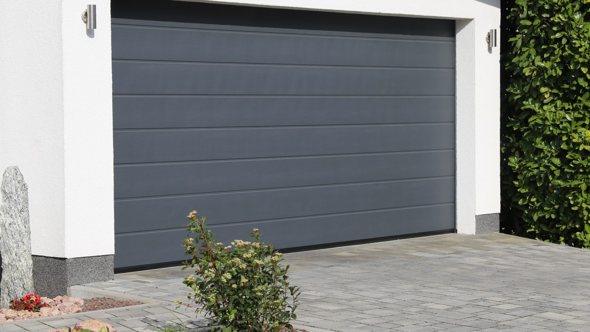 Angled view of a gray, two-car garage door on a white, modern home