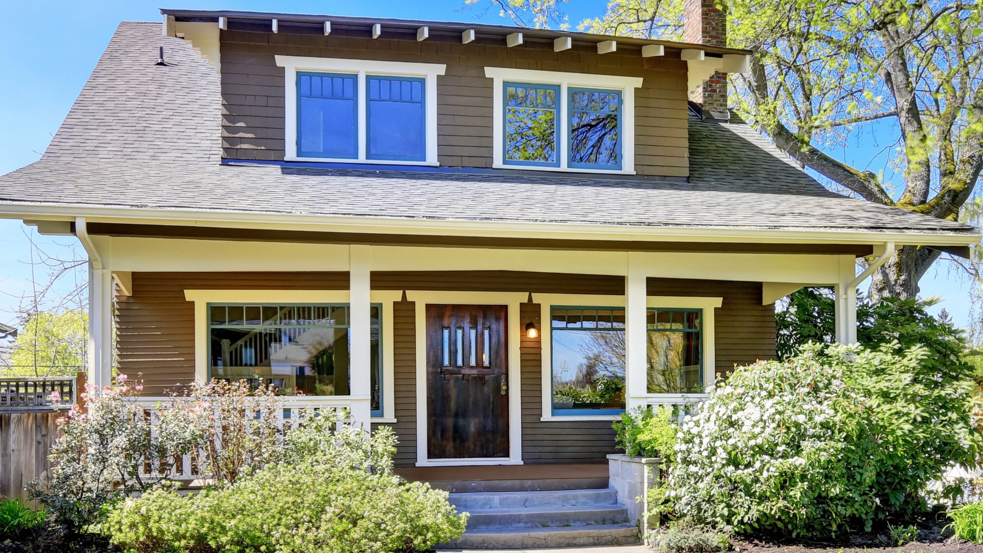 Rustic home exterior with wooden entry door and large new windows