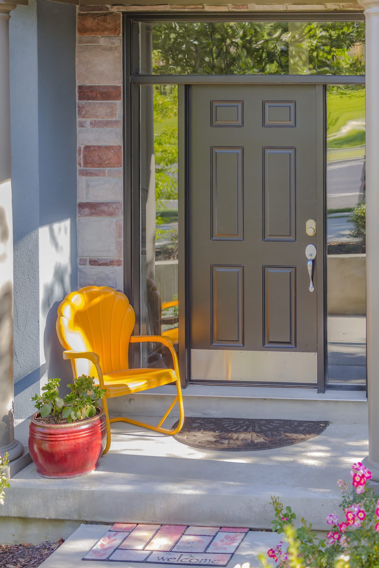 Dark brown entry door with glass windows on side and above the door